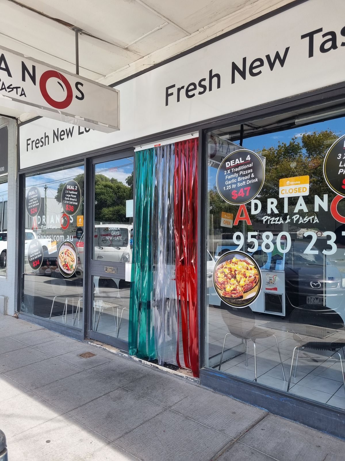 Red and green PVC strip curtain on the shopfront of Adriano's Pizza and Pasta