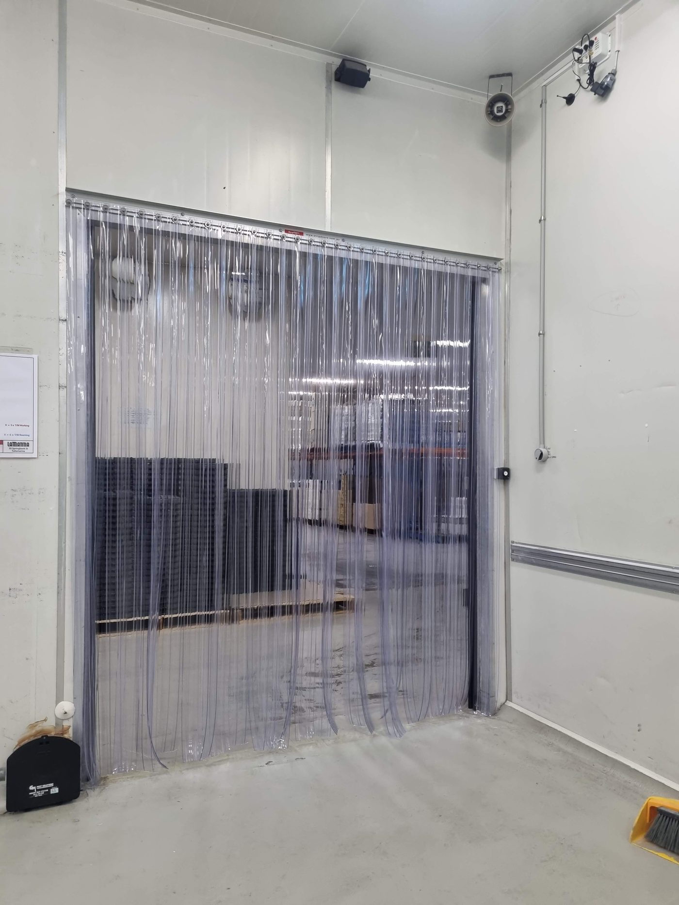 Clear PVC strip curtain fitted to a cool room doorway with a stainless steel hook-on head section