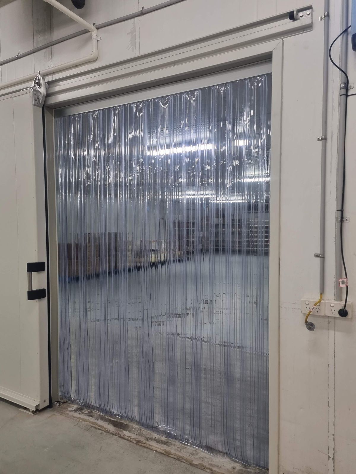 Clear PVC strip curtain fitted to a cool room doorway in a food facility