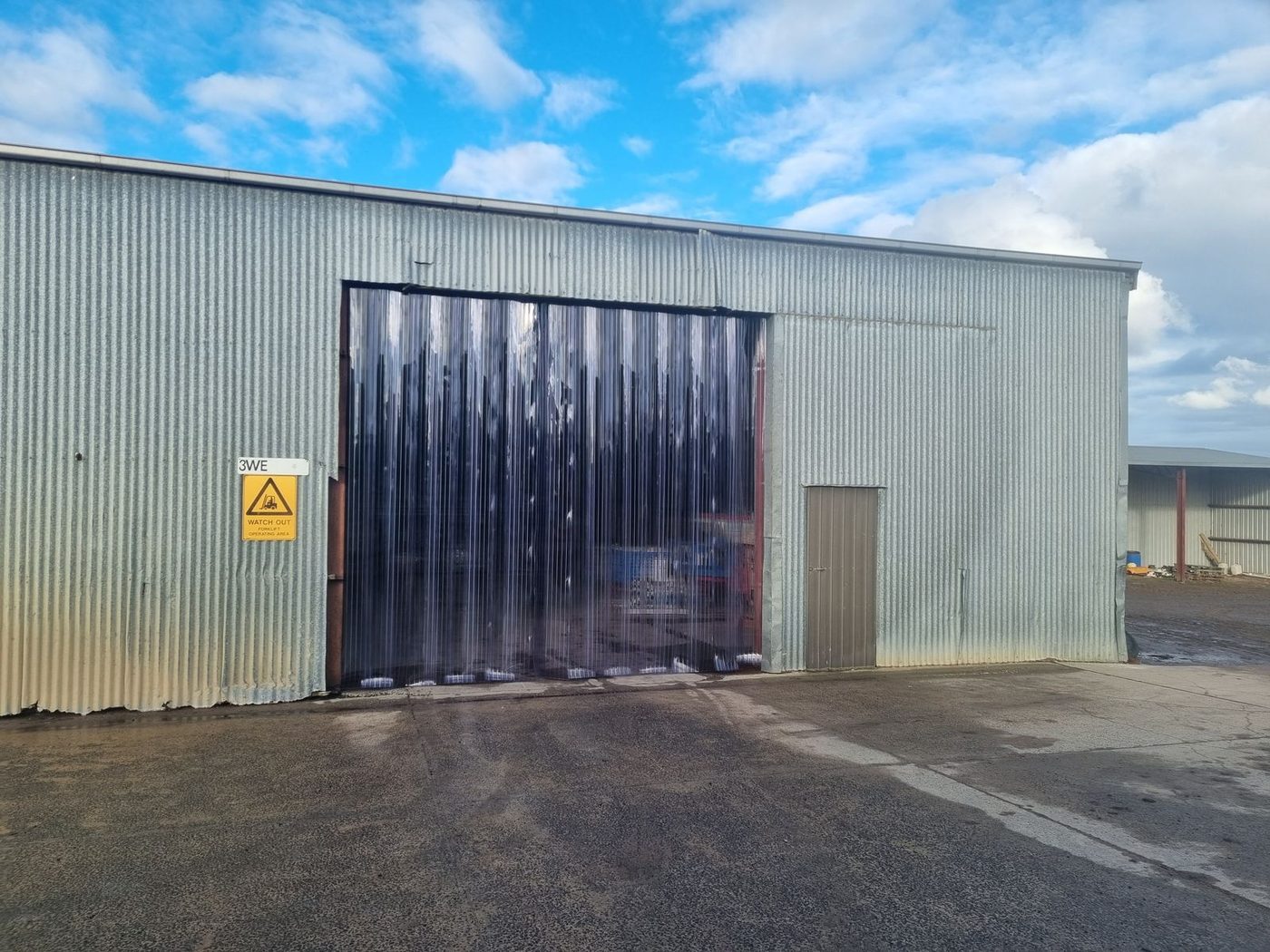 Clear PVC strip door fitted inside an industrial roller door opening