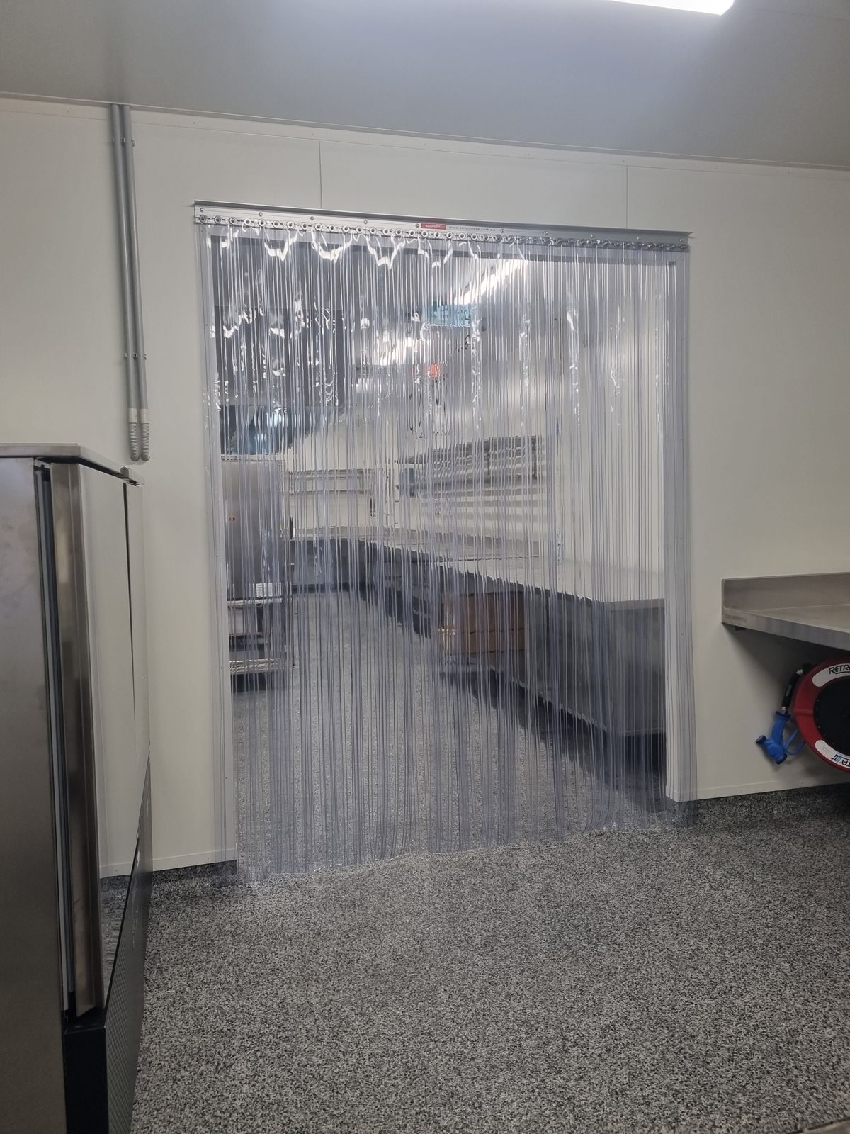 Clear PVC strip curtain fitted to a store cool room doorway